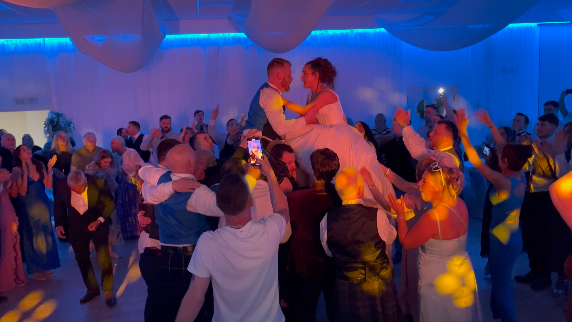 Premier disco weddings bride and groom lifted high by wedding guests during runrig loch lomond at royal musselburgh golf club prestonpans — premier disco weddings